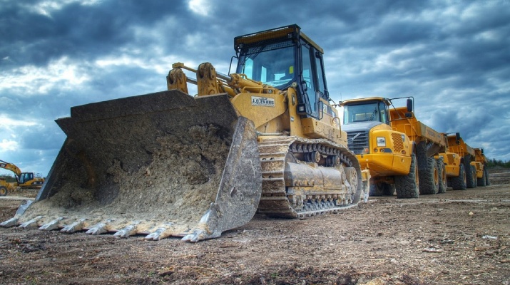 buldozer en vrachtwagens op bouwterrein