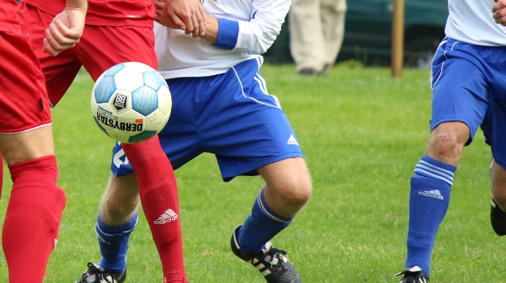 benen van voetbalspelers met bal in de lucht