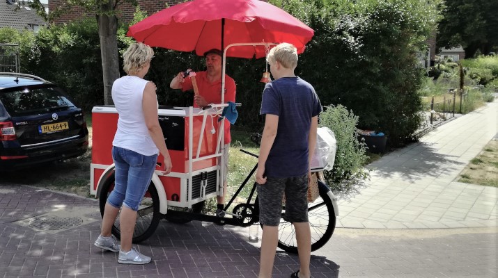 ijskar met fiets en rode parasol, ijscoman en klanten