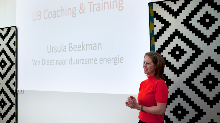 vrouw in rood shirt voor projectiescherm met tekst