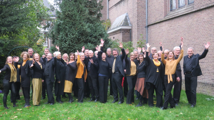 gemengd koor poseert enthousiast voor kerk