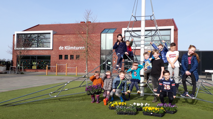 Enkele leerlingen van Basisschool de Klimtoren voor de school met trays violen