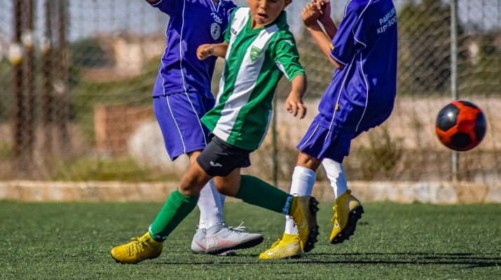 drie jongens voetballen