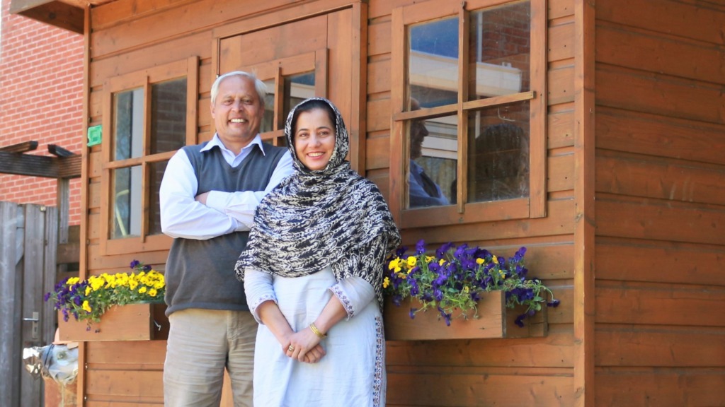 Pakistaanse man en vrouw voor tuinhuis met violen