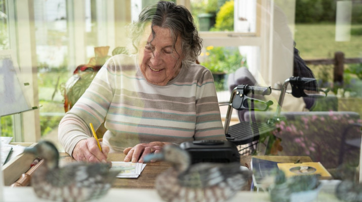 oudere vrouw knutselt aan tafel