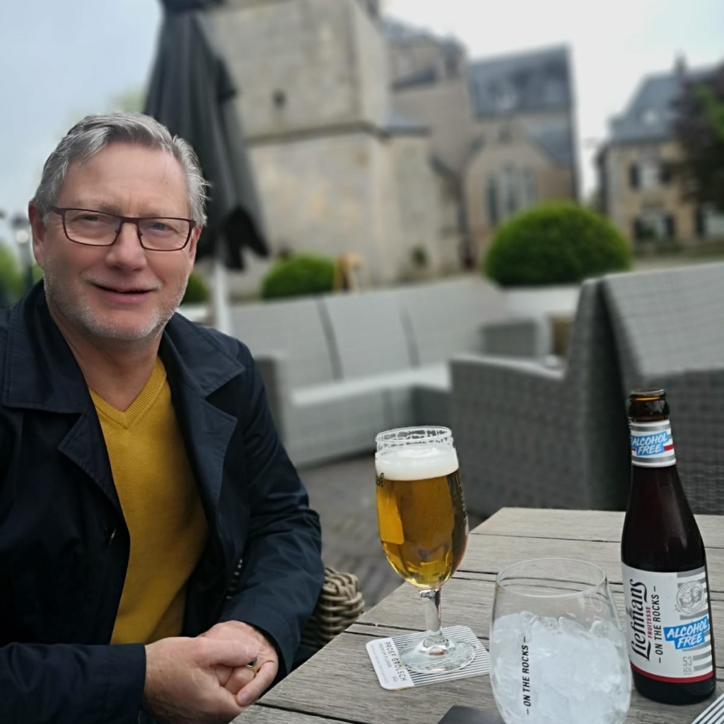 oudere man met biertje op terras